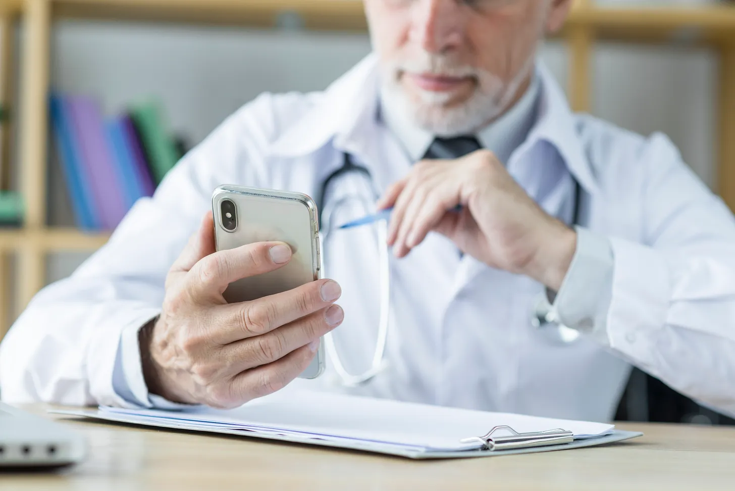 Medico che utilizza uno smartphone per comunicare con i pazienti: rappresentazione dell'uso di WhatsApp nella comunicazione medico-paziente